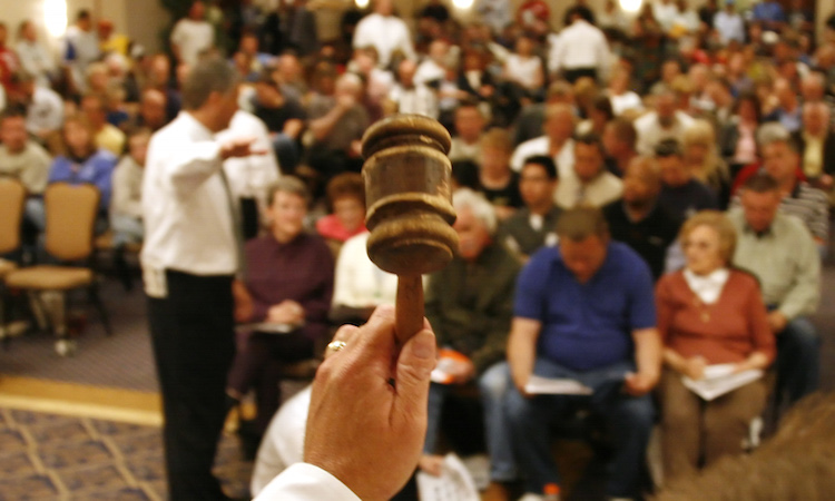 Sam Marshall of Hudson & Marshall (not seen) prepares to drop his gavel signaling bidding is over and another house is sold at an auction of foreclosed homes in Denver