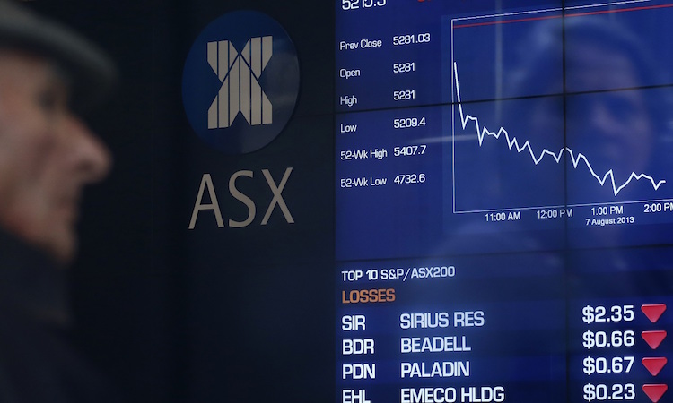A man looks the board of the Australian Securities Exchange in Sydney