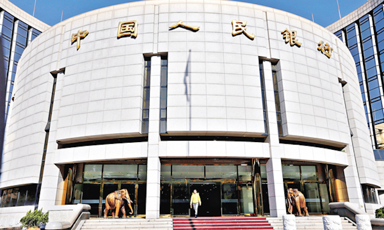 FILE PHOTO: A woman walks out of the headquarters of PBOC in Beijing